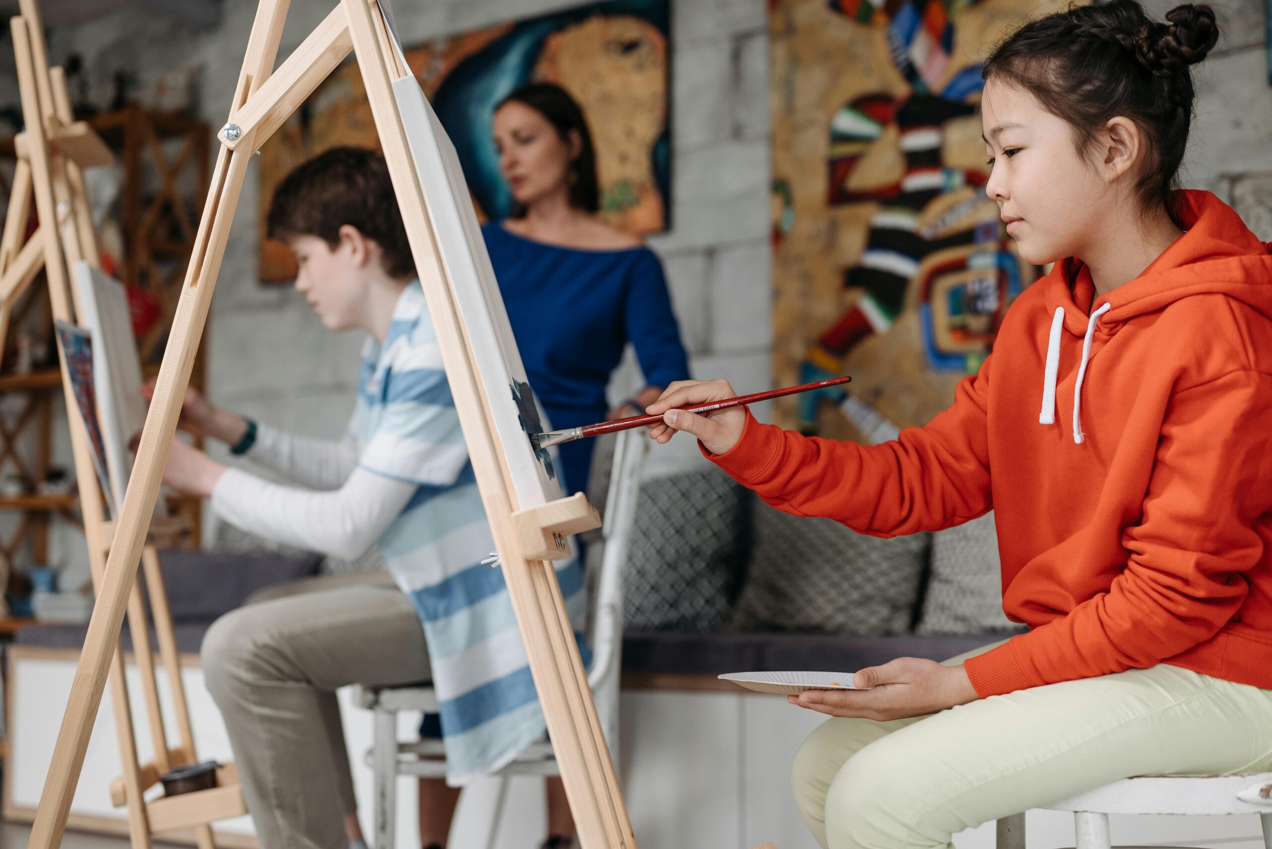 Girl painting at an easel during an art class